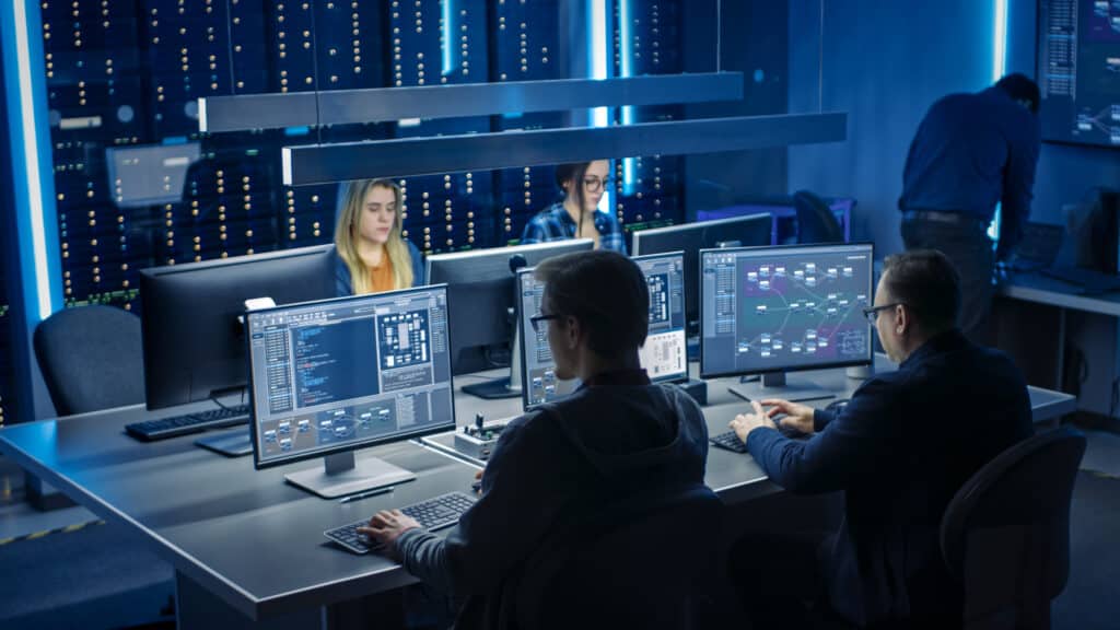 Team of IT Programers Working on Desktop Computers in Data Cente